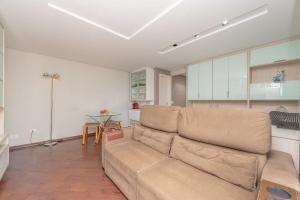 uma sala de estar com um sofá e uma cozinha em Condominio Felice Club em Curitiba