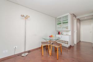 a dining room with a glass table and chairs at Condominio Felice Club in Curitiba