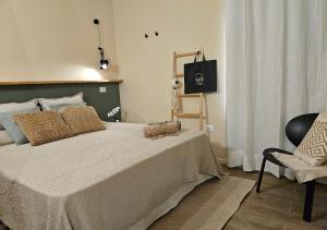 a bedroom with a large bed and a chair at Rayuela Suites San Pantaleo in San Pantaleo
