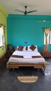 una camera con un grande letto con una parete blu di Kumirmari Ecotourism a Japur