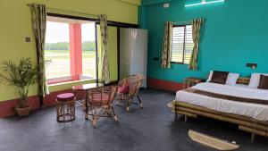 una camera con letto, tavolo e sedie di Kumirmari Ecotourism a Japur