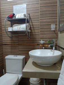 卡哈馬卡的住宿－Hatuchay Inka Apart Hotel，浴室配有白色水槽和卫生间。