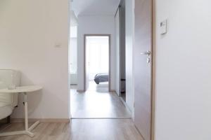 Camera bianca con corridoio, lavandino e tavolo di Great Tourist and Business Apartment a Bratislava
