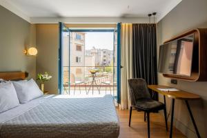 una camera d'albergo con un letto e un balcone di Bob W Eolou ad Atene