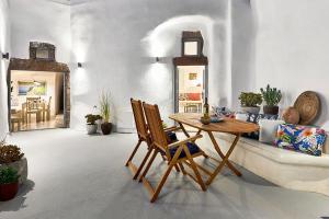 uma sala de estar com uma mesa e cadeiras e um sofá em Villa Agalitsa Cave Houses with Garden Courtyard em Megalokhori