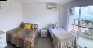 a bedroom with two beds and a window with a view at Pousada Aliança in Salvador