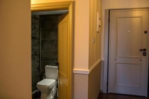 a bathroom with a toilet and a yellow door at City Loft 5 (Stamatina's Luxury Apartments) in Alexandroupoli +10 photos