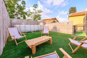 Un patio con dos sillas y un banco de madera. en העוגן והים - The Anchor and the Sea, en Shelomi