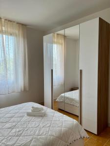 1 dormitorio con 1 cama blanca grande y espejo en Casa Sassuolo, en Sassuolo