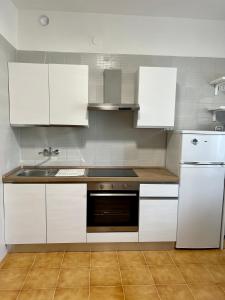 una cocina con armarios blancos y fregadero en Casa Sassuolo, en Sassuolo