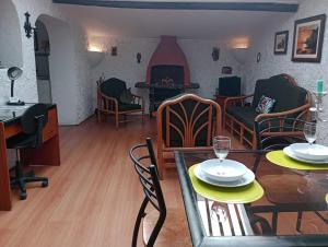 Hatuchay Inka Apart Hotel في كاخاماركا: غرفة معيشة مع طاولة وكراسي