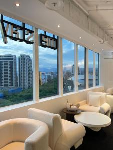 Habitación con sillas, mesas y ventanas grandes. en 美寓藝術文旅 Meistay Art Gallery Hotel, en Taipéi