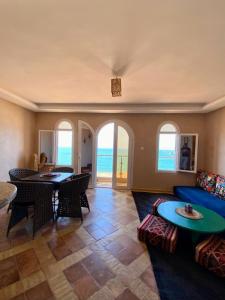 a living room with a blue couch and a table at Dar diafa samira in Mirleft