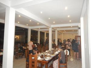 eine Gruppe von Menschen, die an einem Tisch in einem Restaurant sitzen in der Unterkunft Yala Hotel Elephant Eye in Tissamaharama
