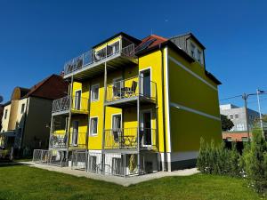 un edificio amarillo y verde con balcones en AJO Vetmed en Viena
