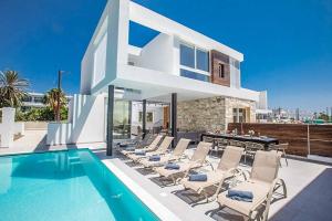 een villa met een zwembad en ligstoelen bij Nissi Cube 4 KB4 in Ayia Napa