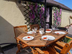 einen Holztisch mit Tellern und Weingläsern darauf in der Unterkunft The Funky Flat in Holywell