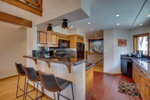 a kitchen with a bar with three stools at Bright Downtown Telluride Condo - Steps to Lift! in Telluride