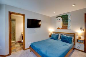 - une chambre avec un lit bleu et une télévision murale dans l'établissement Bright Downtown Telluride Condo - Steps to Lift!, à Telluride 31 autres photos