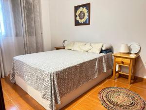 a bedroom with a bed with a table and a clock on the wall at Apartamento Salo in Candelaria