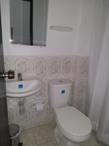 a bathroom with a white toilet and a sink at Hotel Central Park in El Espinal