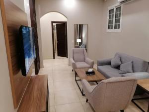 a living room with two couches and a tv at Vital House Apartments شقق البيت الحيوي in Jeddah