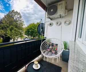 un porche con una silla mecedora en el balcón en Apartment "Mimoza 1" self check-in, self check-out en Otočac
