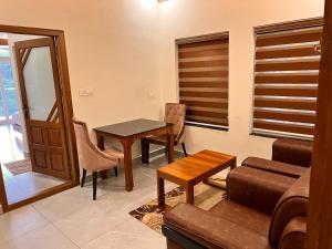 a living room with a table and a couch at Blue Peaks Holidays Swimming Pool Cottage Munnar in Munnar