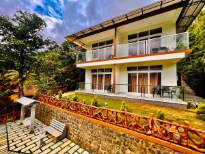 ein Haus mit einem Zaun davor in der Unterkunft Blue Peaks Holiday Home Munnar in Munnar