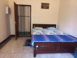1 dormitorio con 1 cama con sábanas azules y blancas en Ommie Villa, en Hikkaduwa