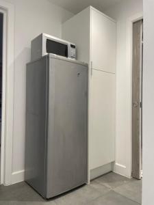 a microwave sitting on top of a refrigerator at Skylight Deluxe Apartment with free parking, close to Windsor, Legoland and Heathrow in Farnham Royal