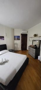 a bedroom with a large white bed and a dresser at Mi Casita in Arzachena