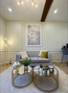 a living room with a couch and two tables at Le Lamartine - vue Saône - Baignoire îlot in Mâcon