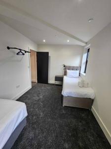 a hotel room with two beds and a window at Stunning City Center Prime Location Flat - TV in every bedroom in Neath