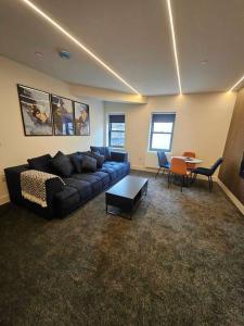 sala de estar con sofá y mesa en Stunning City Center Prime Location Flat - TV in every bedroom en Neath