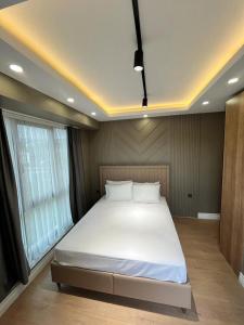 a bedroom with a large white bed with a window at Serim Residence in Kocaeli
