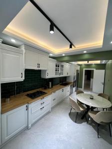 a kitchen with white cabinets and a table with chairs at Serim Residence in Kocaeli