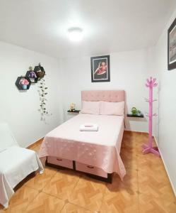 a bedroom with a pink bed in a room at Female Accommodation Experience in front of Lima Airport in Lima