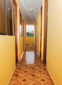 a corridor of an office with yellow walls and wooden floors at Female Accommodation Experience in front of Lima Airport in Lima