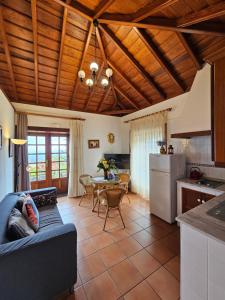 uma cozinha e sala de estar com um sofá e uma mesa em Corral de Payo Casita Blanca em Breña Baja