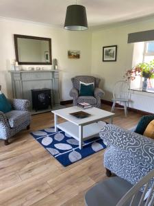 a living room with a couch and a coffee table at Baytree Farmhouse in Garryvoe