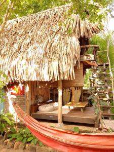 una hamaca frente a una cabaña con una cama en ella en Monsoon Eco Resort - Whisky point Arugambay, en Pottuvil