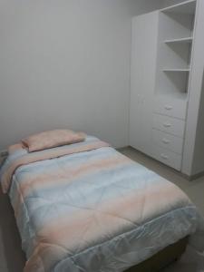een slaapkamer met een bed en een witte kast bij Apartamento Meta Home zona exclusiva in Piura