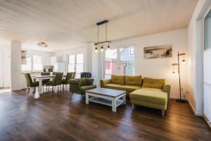 ein Wohnzimmer mit einem Sofa, Stühlen und einem Tisch in der Unterkunft Ferienhäuser Baltic Lagoon Haus 14 in Fuhlendorf