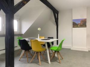 une salle à manger avec une table blanche et des chaises vertes dans l'établissement Ruhrpott Apartment Zentral Grand, à Herne