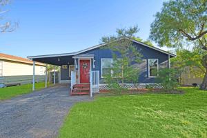 ein blaues Haus mit einer roten Tür in der Unterkunft Home Sweet Home - Peace, Love, & Enjoy in Kingsville