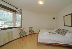 iFlat Madonna di Campiglio Alpino Orange tesisinde bir odada yatak veya yataklar