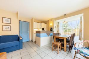 ein Wohnzimmer mit einem blauen Sofa und einem Tisch in der Unterkunft Les Maisons de Belle Dune - maeva Home - Maison 4 Pièces 8 Personnes Sélection MAE-3688 in Fort-Mahon-Plage + 10 Fotos