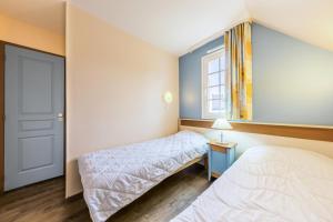 ein Schlafzimmer mit zwei Betten und einem Fenster in der Unterkunft Les Maisons de Belle Dune - maeva Home - Maison 4 Pièces 8 Personnes Sélection MAE-3688 in Fort-Mahon-Plage
