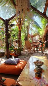 un patio con mesa, sillas y palmeras en Monsoon Eco Resort - Whisky point Arugambay en Pottuvil